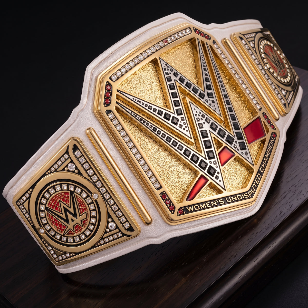 WWE Women's Undisputed Championship belt with a gold and white design, featuring red and black accents, displayed on a dark wooden surface.