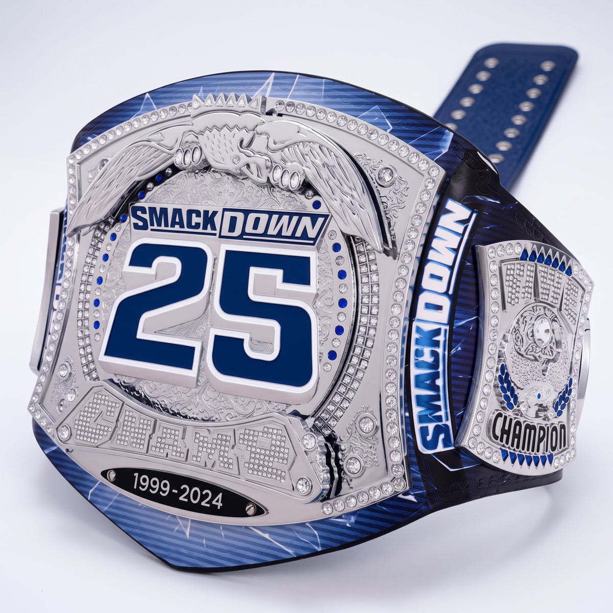 A custom championship belt with a blue and silver design, featuring the text 'SMACKDOWN 25' and '1999-2024' on a white background.