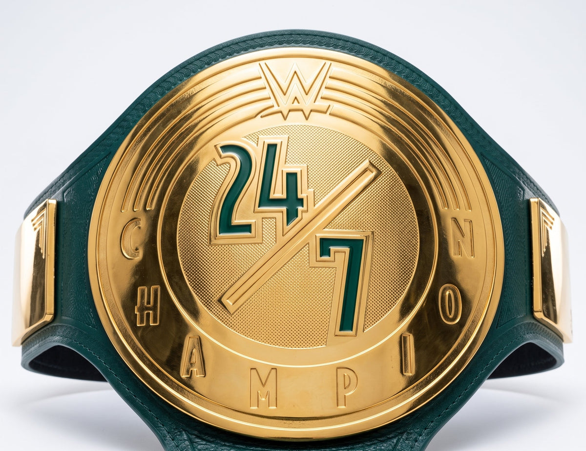 A close-up of a championship belt with a large gold-toned medallion featuring the WWE logo and '24/7 Champion' text, attached to a dark green leather strap on a light gray background.