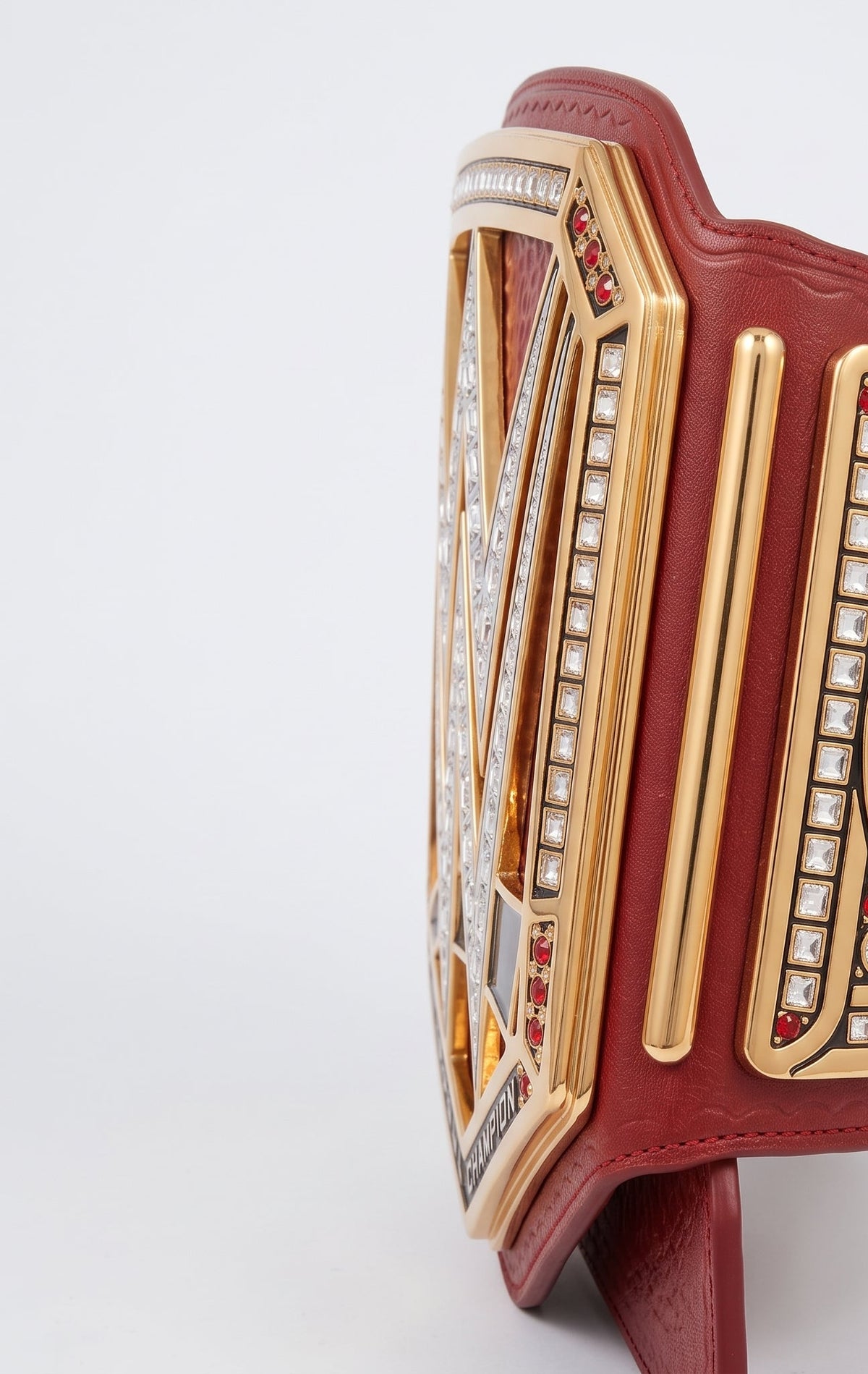A custom WWE championship belt featuring a burgundy leather strap, gold-plated metal plates, and clear rhinestones, displayed on a white background.
