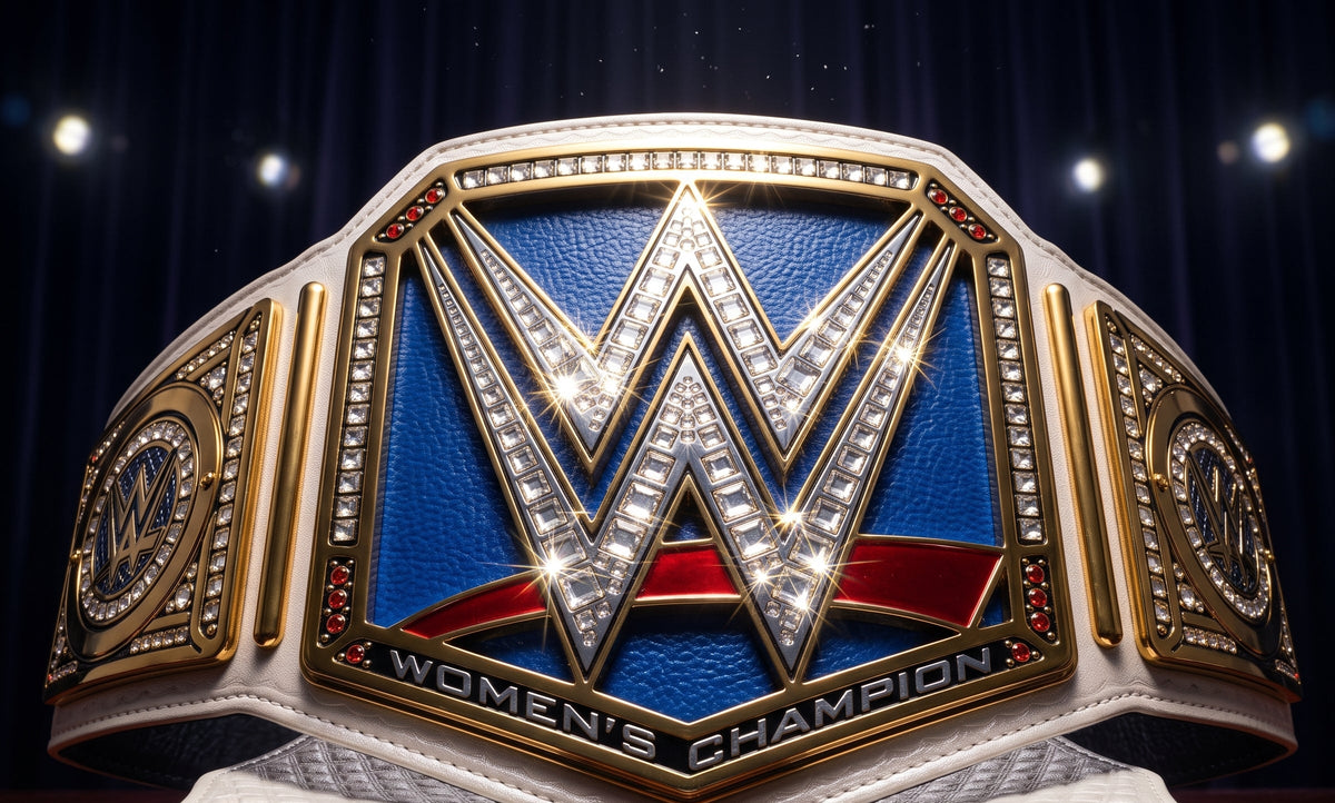 A WWE Women's Champion belt displayed prominently, featuring a large central 'W' emblem with sparkling rhinestone-like detailing, a blue background, red ribbon accents, and gold-toned side plates on a white leather strap.