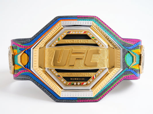 A colorful UFC World Champion belt with a gold central plate and a vibrant, patterned strap featuring pink, blue, green, yellow, and black woven details, shown on a white background.